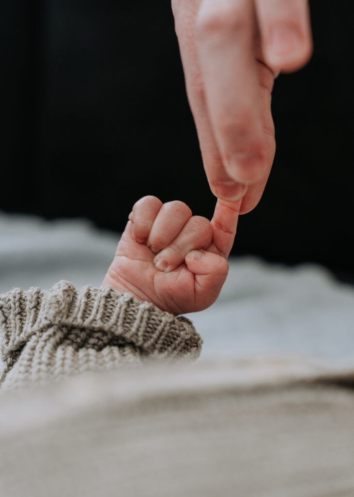 Zarte Verbindung – Neugeborenenhand in Mamas Hand