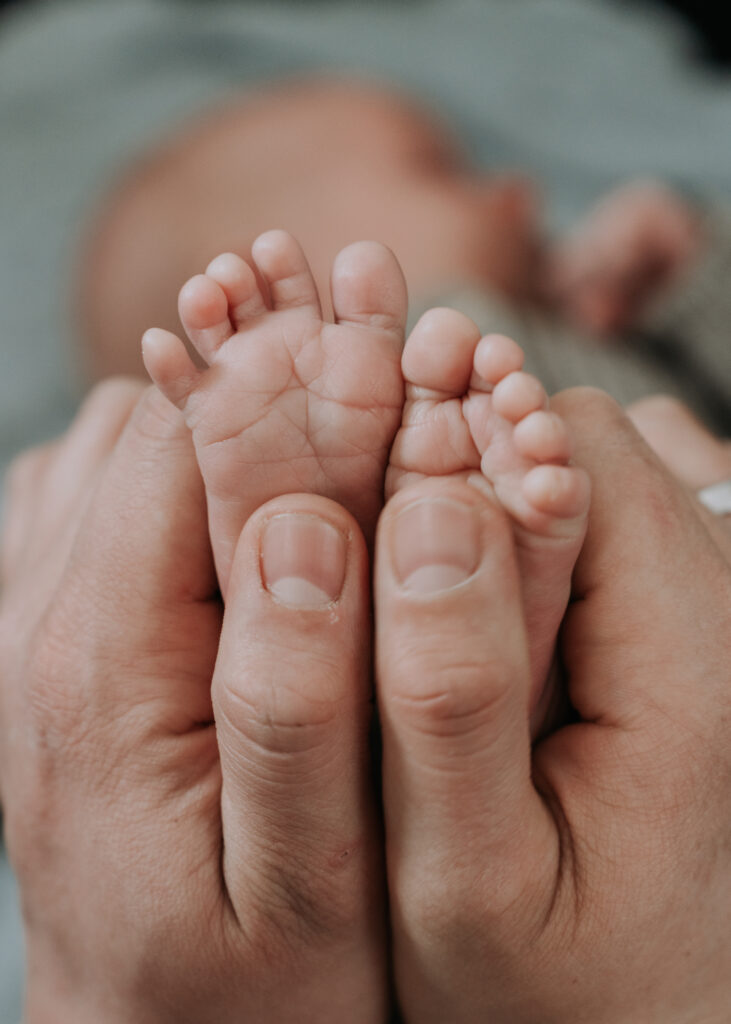 Neugeborenenshooting zuhause – liebevoller Moment mit Babyfüßen