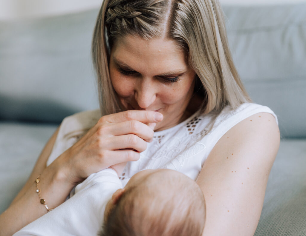 Neugeborenenshooting zuhause – inniger Moment zwischen Mama und Baby